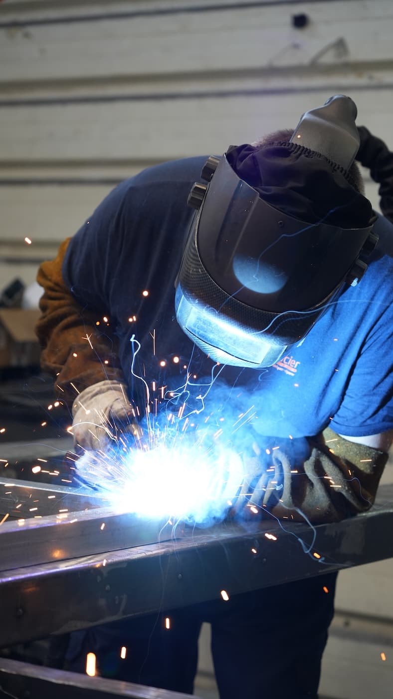 Soudeur Novacier en train de souder une structure métallique dans l'atelier de Cheval-Blanc